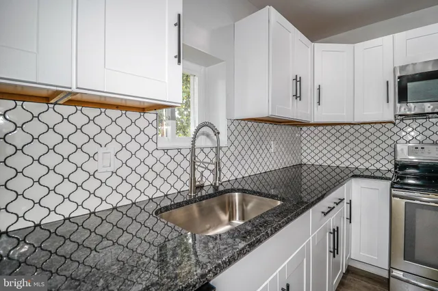 a kitchen with a sink and a stove top oven
