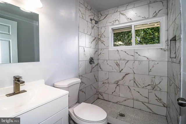 a white toilet sitting next to a bathroom sink