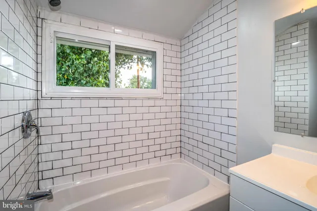 a bathroom with a bathtub and next to a window