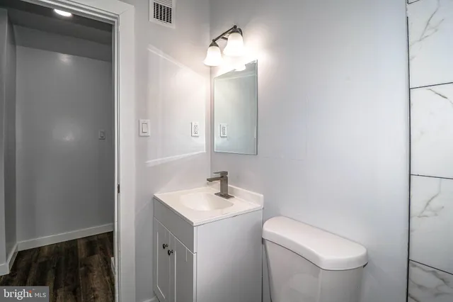 a bathroom with a toilet sink and mirror