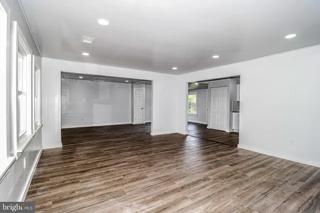 a view of empty room with wooden floor and entryway