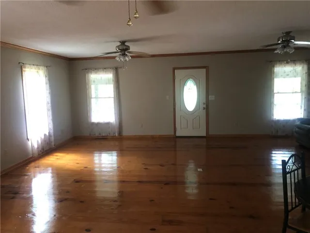 a view of a livingroom with wooden floor and a ceiling fan