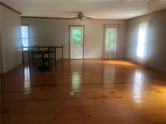 a view of empty room with window and wooden floor