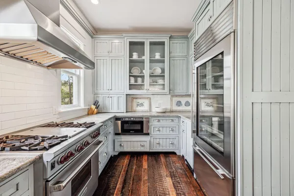 a kitchen with stainless steel appliances a stove and white cabinets