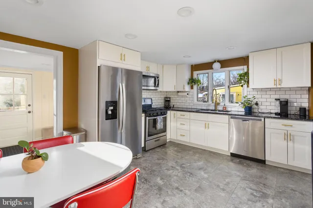 a kitchen with stainless steel appliances a sink stove and refrigerator