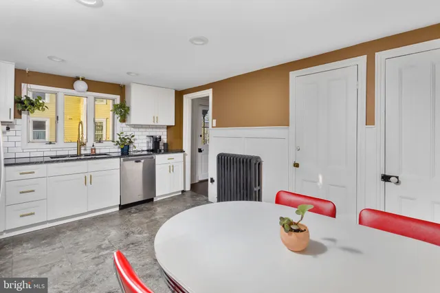 a kitchen with a table chairs sink and cabinets