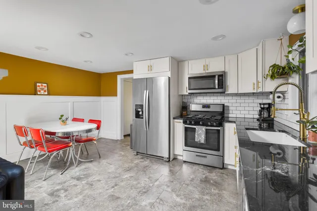 a kitchen with stainless steel appliances kitchen island granite countertop a refrigerator and a stove top oven