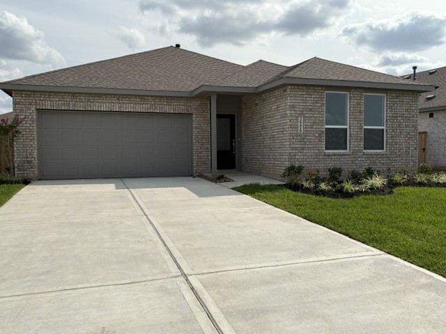 26419 Virginia Wild Rye Lane Katy, TX 77493 - Photo 2 of 31 This photo shows a modern single-story brick house with a two-car garage, a well-maintained lawn, and a simple landscaped front yard.