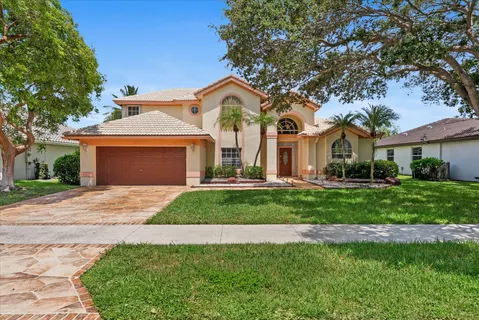 a front view of a house with a garden and trees