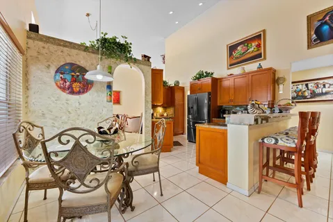 a very nice looking dining room with kitchen island furniture a chandelier and a view of living room