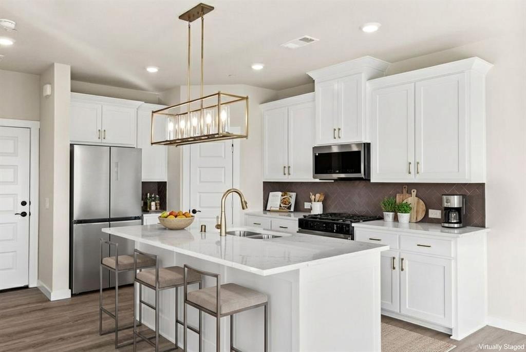 2028 Aldrich Road Celina, TX 75009 - Photo 15 of 40 a kitchen with stainless steel appliances a sink a stove a refrigerator cabinets and a counter top space