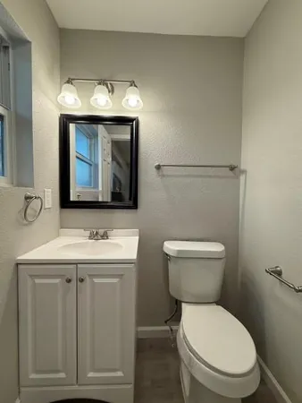 a bathroom with a toilet sink and mirror