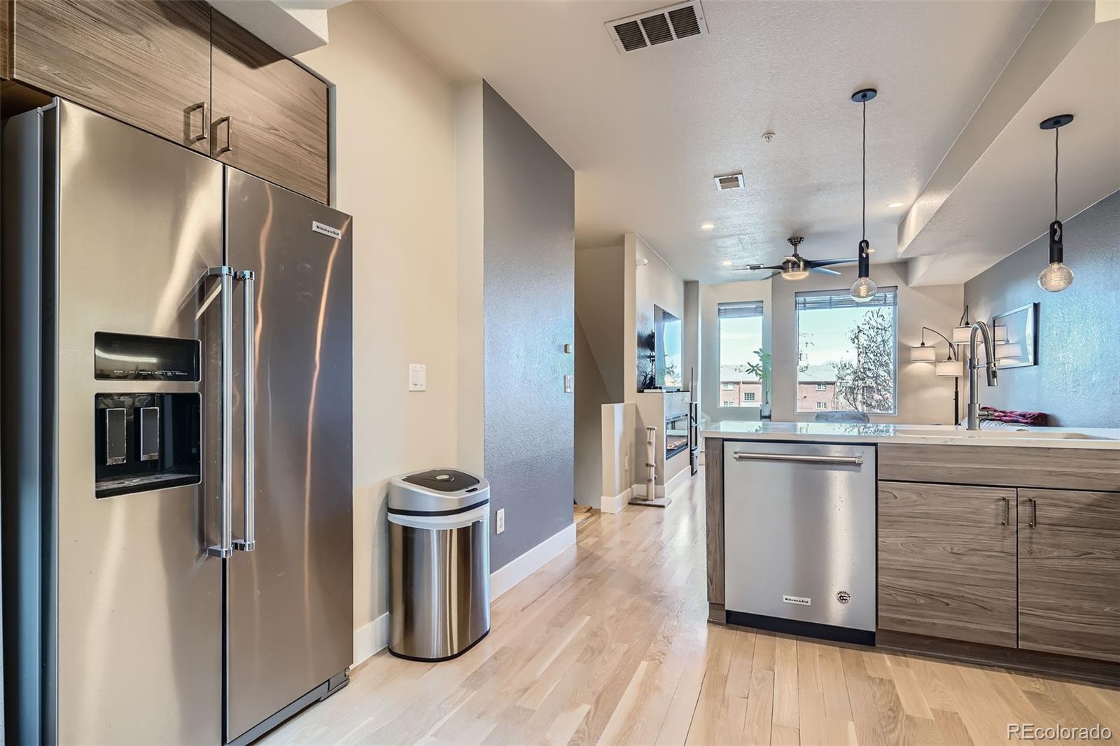 1583 Grove Street, Unit 5 Denver, CO 80204 - Photo 11 of 39 a kitchen with stainless steel appliances a refrigerator a sink a stove and white cabinets