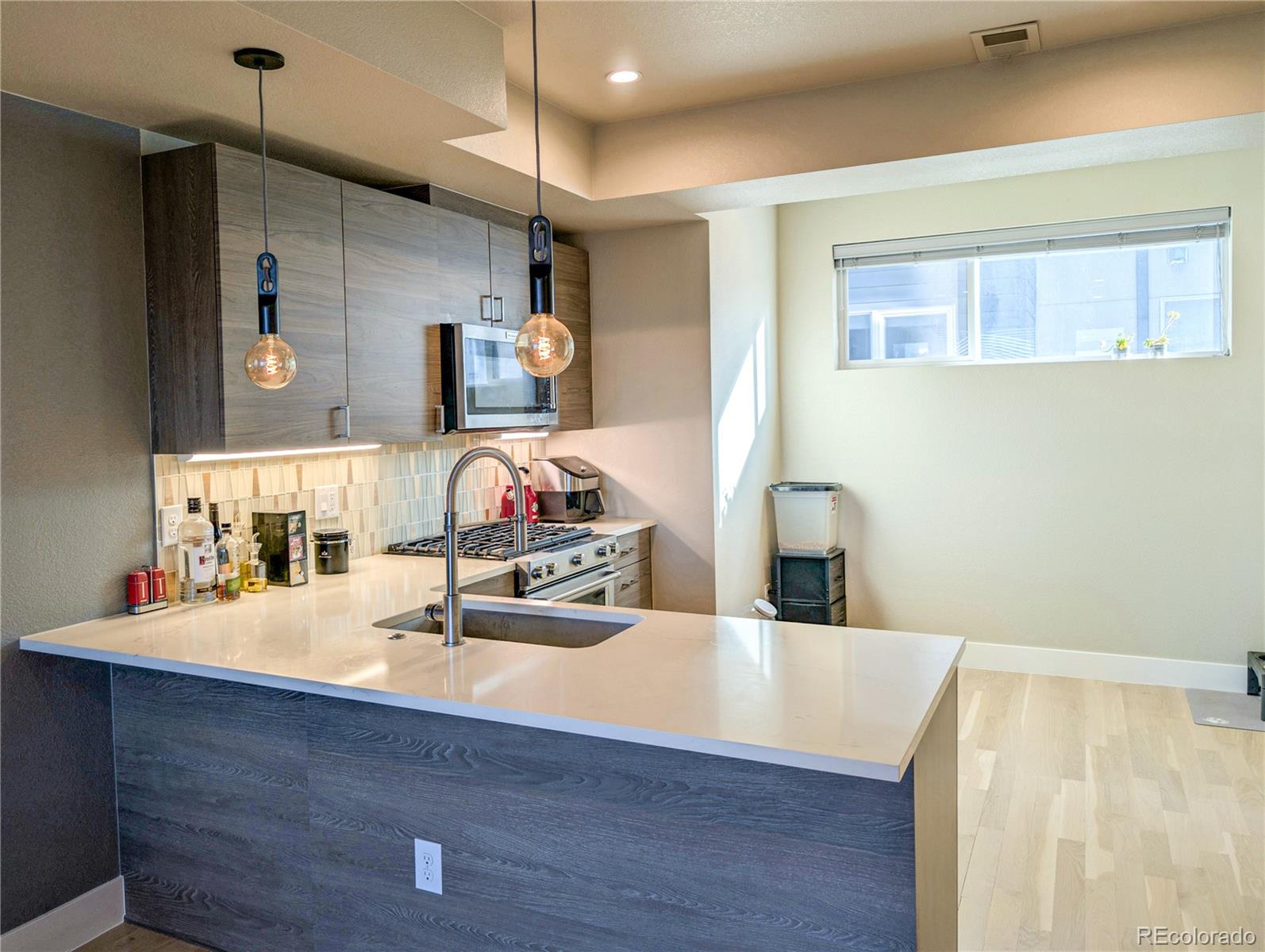1583 Grove Street, Unit 5 Denver, CO 80204 - Photo 15 of 39 a room with kitchen island a wooden floor and a sink