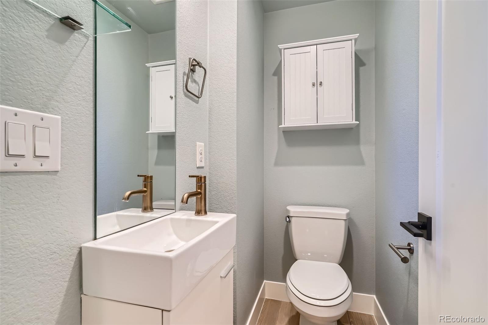 1583 Grove Street, Unit 5 Denver, CO 80204 - Photo 16 of 39 a bathroom with a toilet sink vanity and mirror