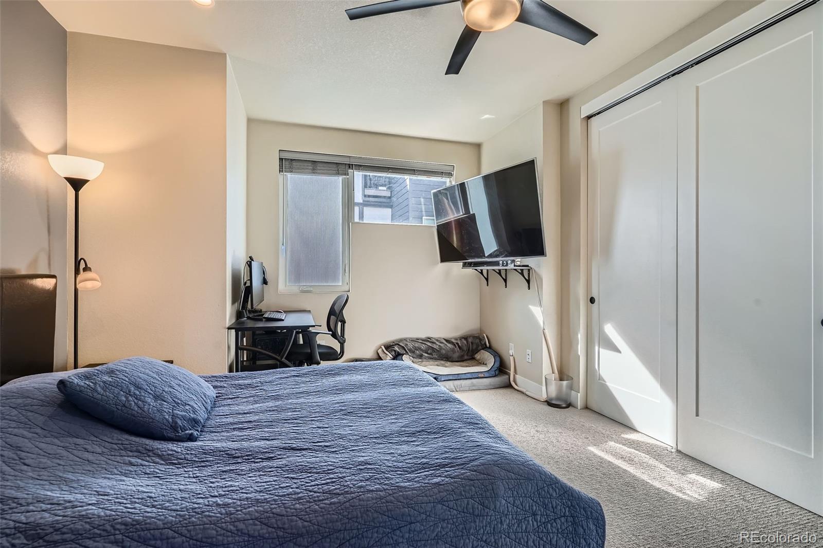 1583 Grove Street, Unit 5 Denver, CO 80204 - Photo 19 of 39 a bedroom with a bed and a flat tv screen