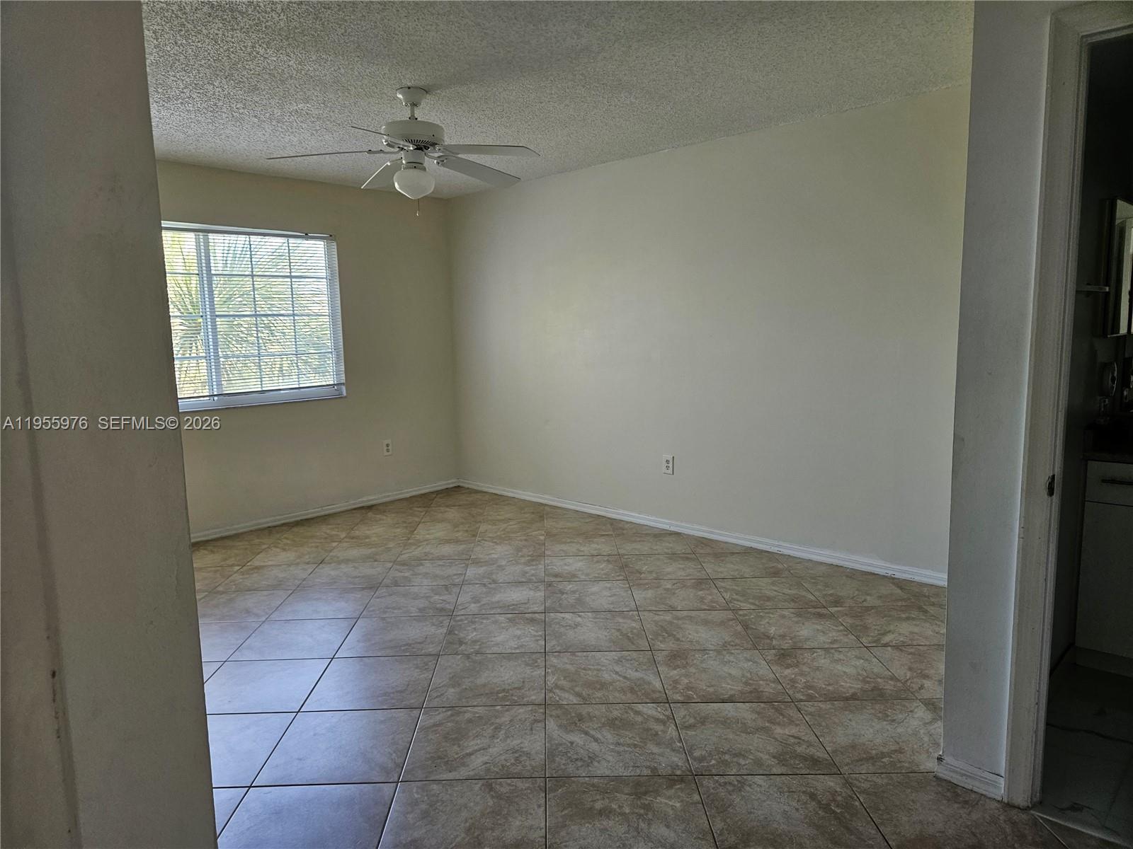 5011 Wiles Road, Unit 306 Coconut Creek, FL 33073 - Photo 7 of 17 a view of a livingroom with a ceiling fan and window