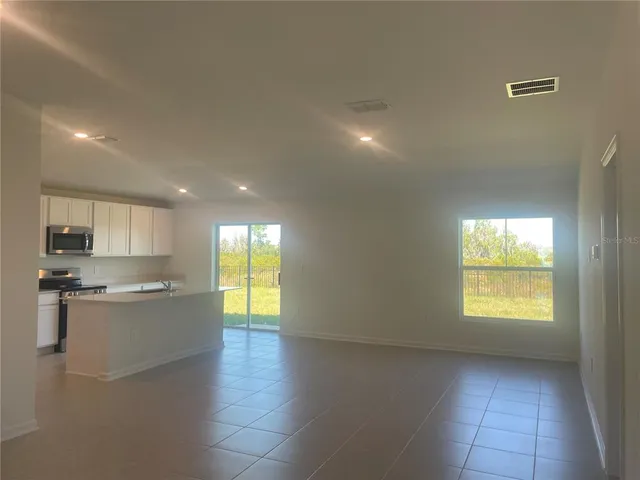 a kitchen with stainless steel appliances granite countertop a sink a stove a refrigerator a window and cabinets