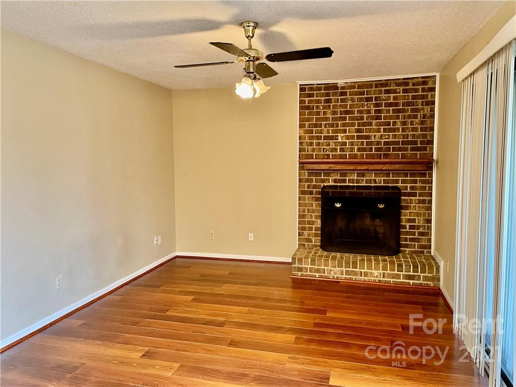 11046 Running Ridge Road Charlotte, NC 28226 - Photo 9 of 15 a view of an empty room with wooden floor and a fireplace