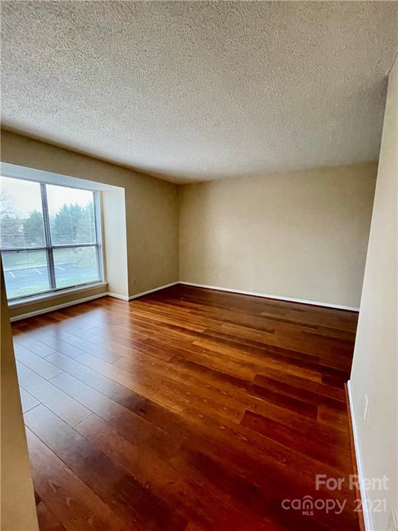 11046 Running Ridge Road Charlotte, NC 28226 - Photo 10 of 15 an empty room with wooden floor and windows