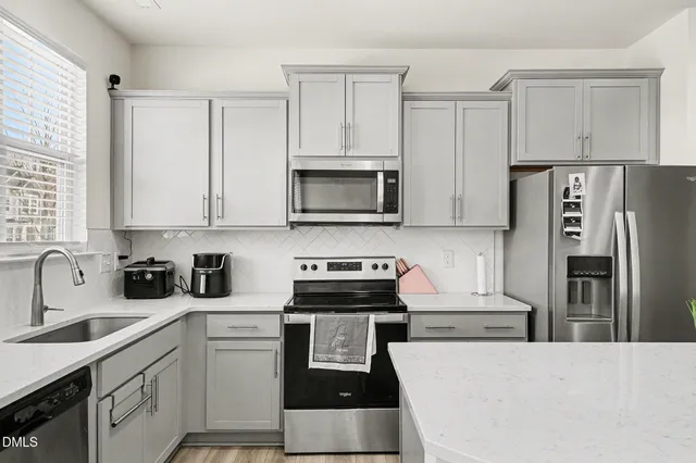a large kitchen with stainless steel appliances and a refrigerator