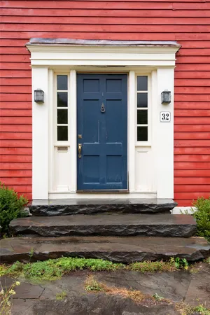 a small white building with a small yard and a large window