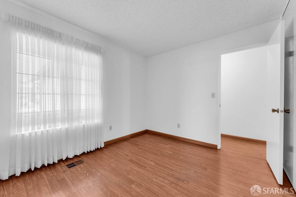 184 Pearce Hercules, CA 94547 - Photo 43 of 61 an empty room with wooden floor and windows