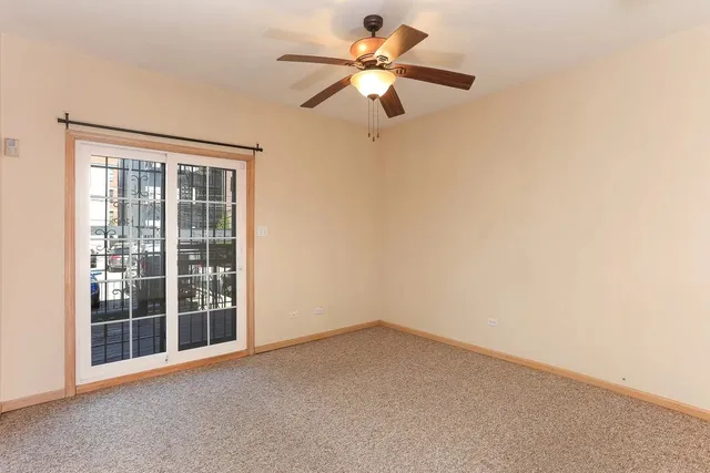 an empty room with closet and a chandelier fan