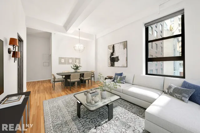 a living room with furniture a flat screen tv and a large window