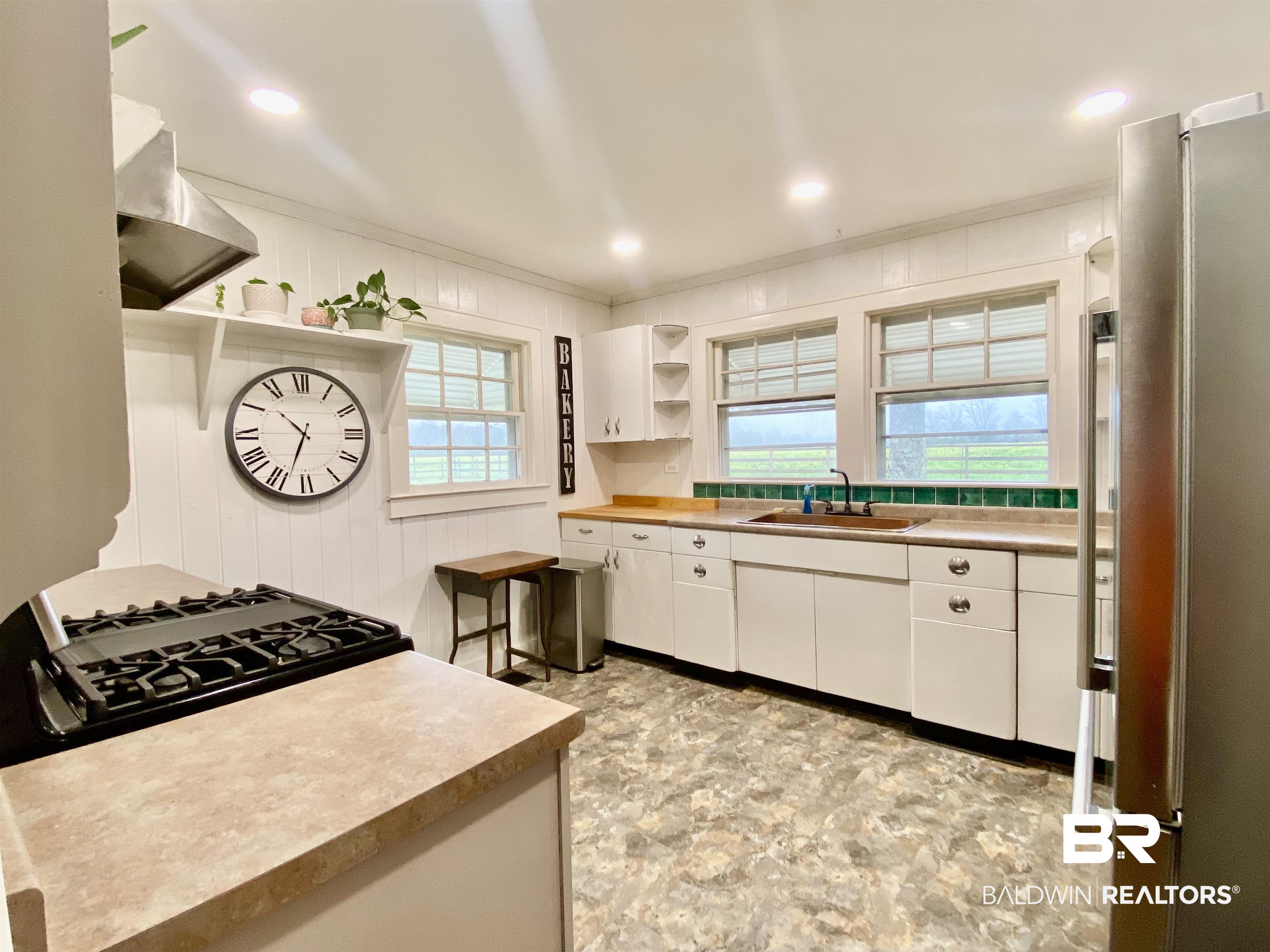 770 Arena Road Frisco City, AL 36445 - Photo 17 of 51 Kitchen featuring open shelves, freestanding refrigerator, ornamental molding, a sink, and white cabinetry