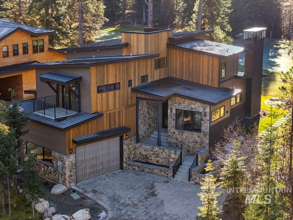 Exterior space featuring a standing seam roof, a metal roof, a chimney, and a patio