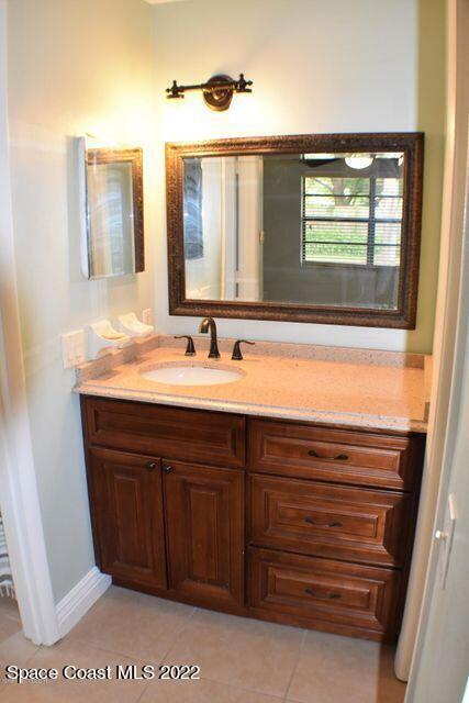 3335 Jay Tee Drive Melbourne, FL 32901 - Photo 14 of 37 a bathroom with a sink vanity and mirror
