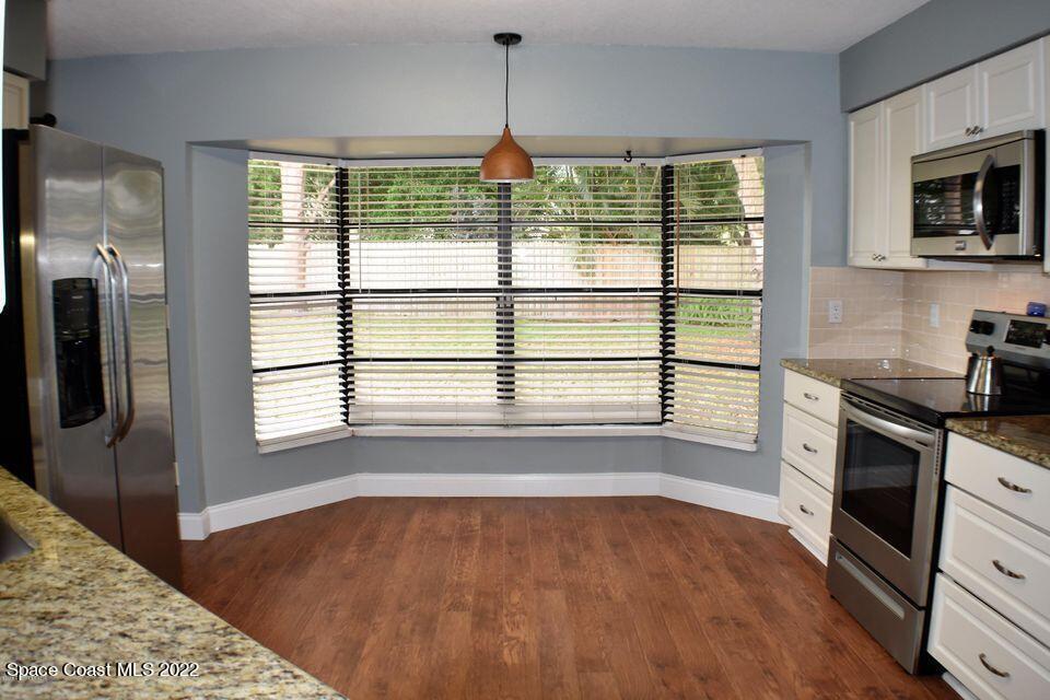3335 Jay Tee Drive Melbourne, FL 32901 - Photo 2 of 37 a view of a kitchen with a stove cabinets and a wooden floor