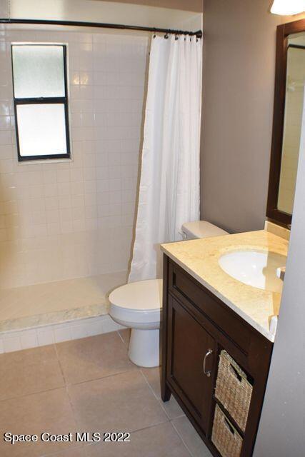 3335 Jay Tee Drive Melbourne, FL 32901 - Photo 21 of 37 a bathroom with a sink a toilet a window and a shower