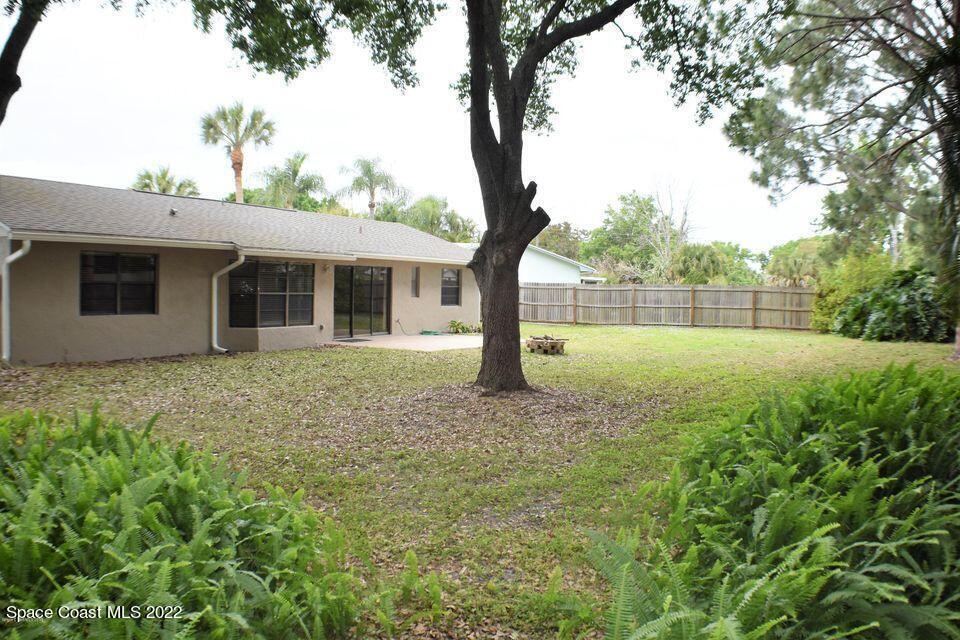3335 Jay Tee Drive Melbourne, FL 32901 - Photo 25 of 37 a backyard of a house with plants and large tree