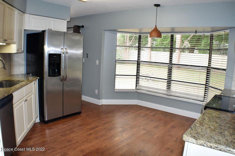 3335 Jay Tee Drive Melbourne, FL 32901 - Photo 3 of 37 a kitchen with stainless steel appliances granite countertop a refrigerator and a sink
