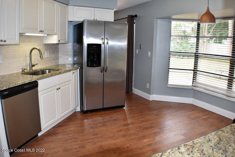 3335 Jay Tee Drive Melbourne, FL 32901 - Photo 4 of 37 a kitchen with granite countertop a refrigerator and a sink