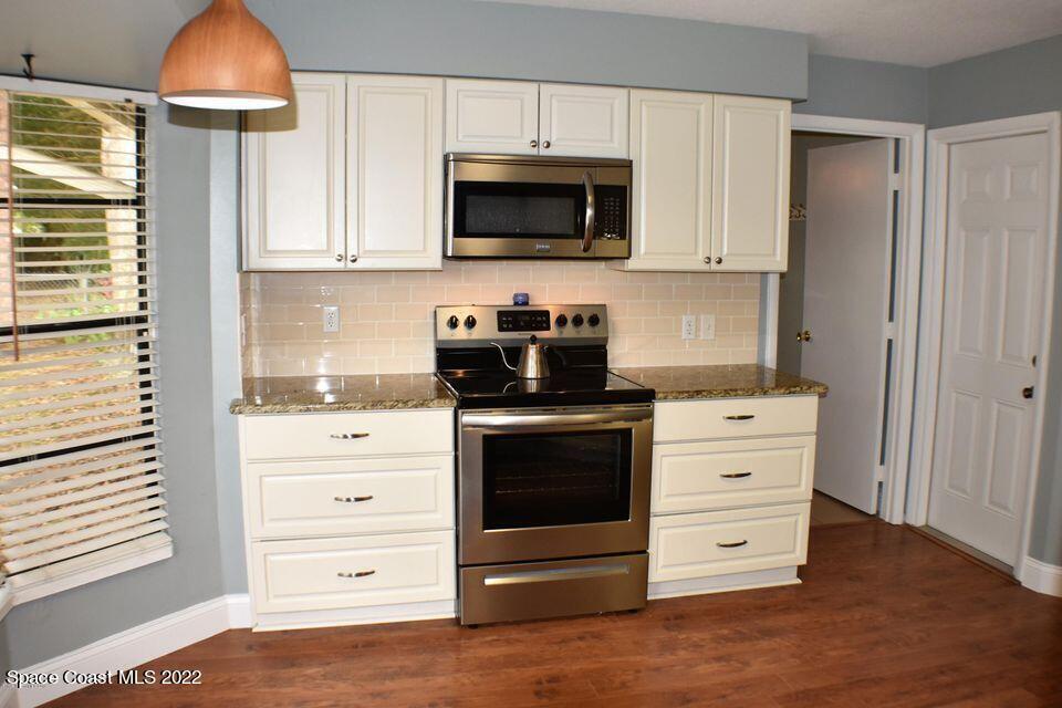 3335 Jay Tee Drive Melbourne, FL 32901 - Photo 6 of 37 a kitchen with stainless steel appliances a stove and a microwave