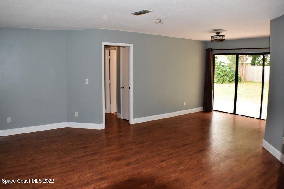3335 Jay Tee Drive Melbourne, FL 32901 - Photo 7 of 37 a view of an empty room with wooden floor and a window