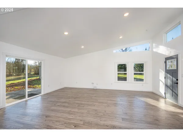 a kitchen with stainless steel appliances a refrigerator a stove a sink a stove and white cabinets