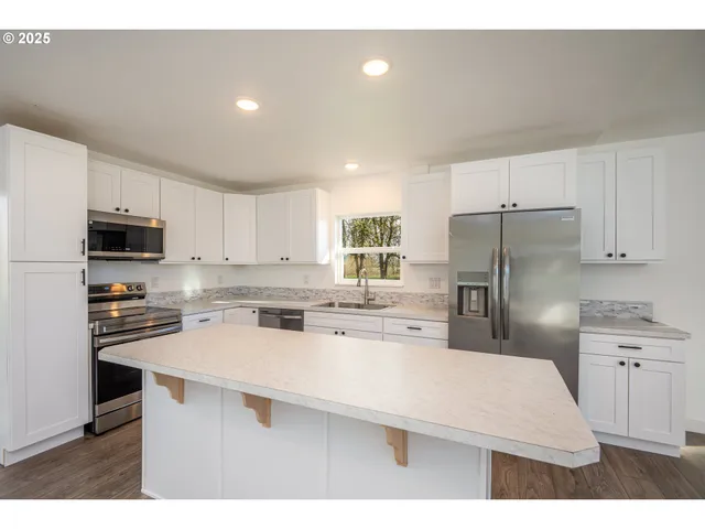 a kitchen with refrigerator cabinets and wooden floor
