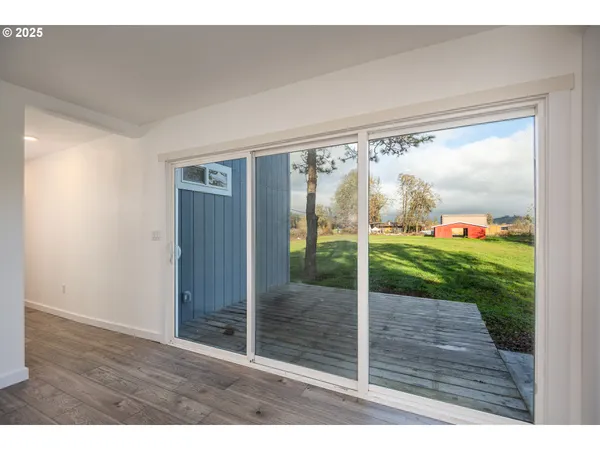 a view of an empty room with wooden floor and fence
