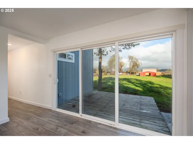 a view of an empty room with wooden floor and fence