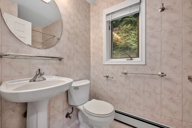 a bathroom with a sink a toilet and a mirror