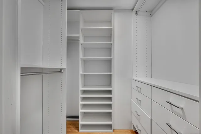 a view of walk in closet with empty racks