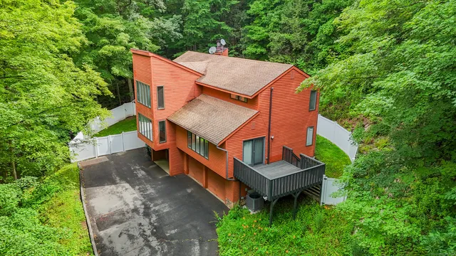 an aerial view of a house with a big yard and large trees