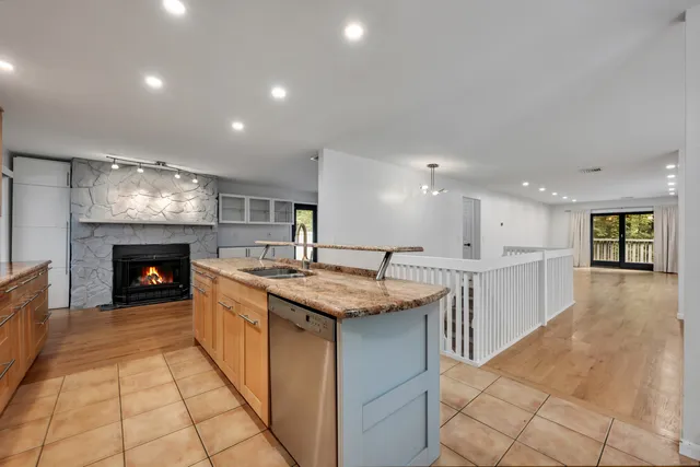 a kitchen with kitchen island granite countertop a stove and a sink
