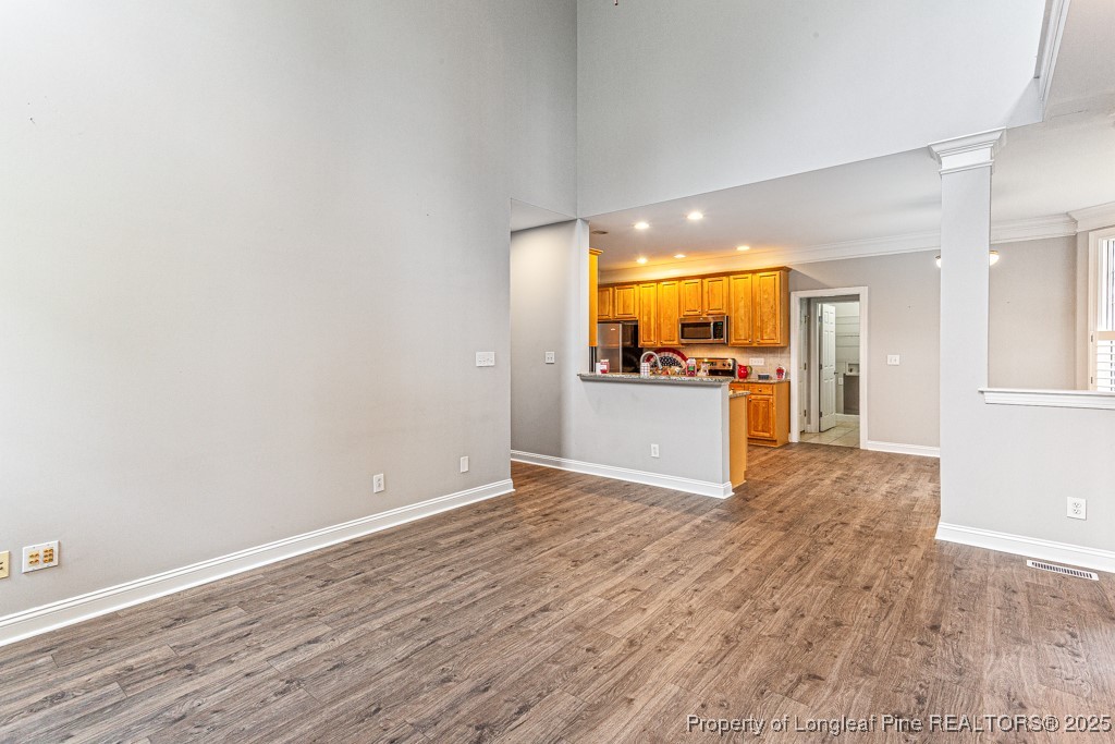 367 Falling Water Road Spring Lake, NC 28390 - Photo 12 of 41 wooden floor in an empty room with a kitchen