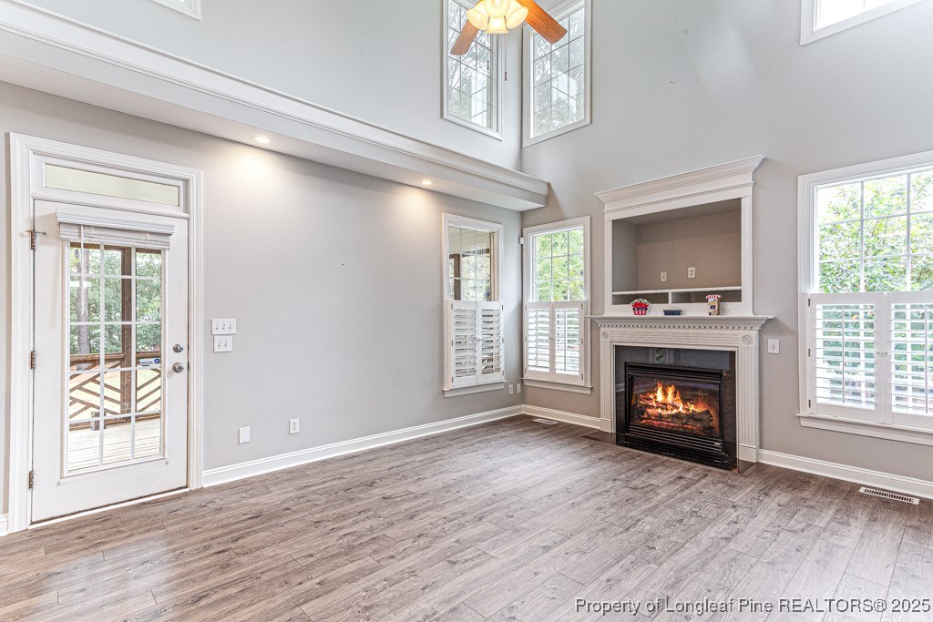 367 Falling Water Road Spring Lake, NC 28390 - Photo 10 of 41 a view of an empty room with wooden floor fireplace and a window