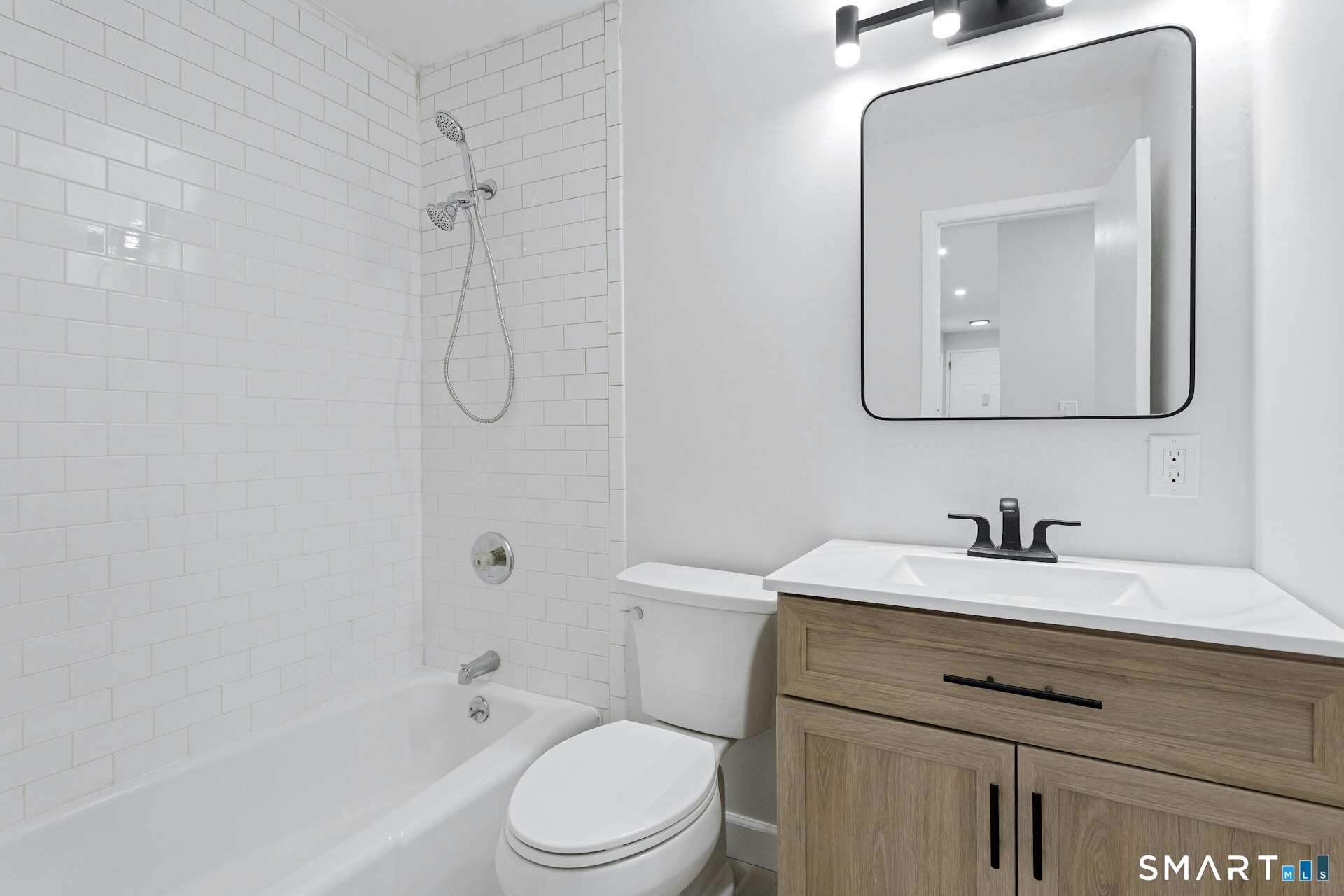154 Cold Spring Road, Unit 18 Stamford, CT 06905 - Photo 18 of 28 a bathroom with a toilet sink vanity tub and mirror